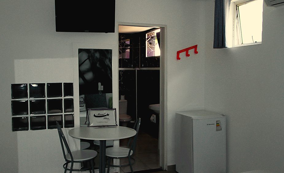 Mesa, frigobar e TV da Suíte Master